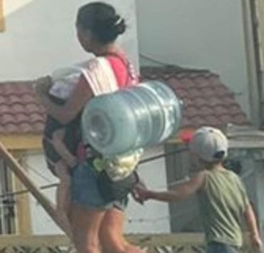 Una imagen se hace viral: Una mujer con sus hijos carga un botellón en Tampico