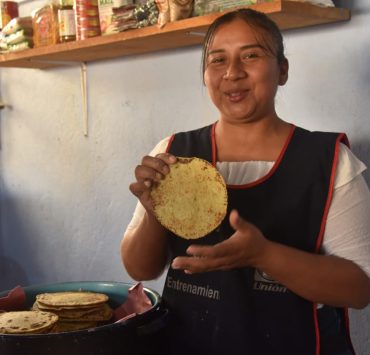 Ella comía tortilla gruesa y café antes de ir a la escuela; hoy, prepara alimentos ricos y nutritivos para sus hijos