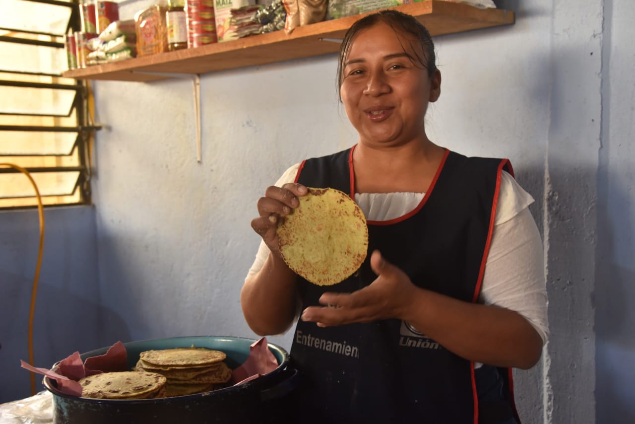 Ella comía tortilla gruesa y café antes de ir a la escuela; hoy, prepara alimentos ricos y nutritivos para sus hijos